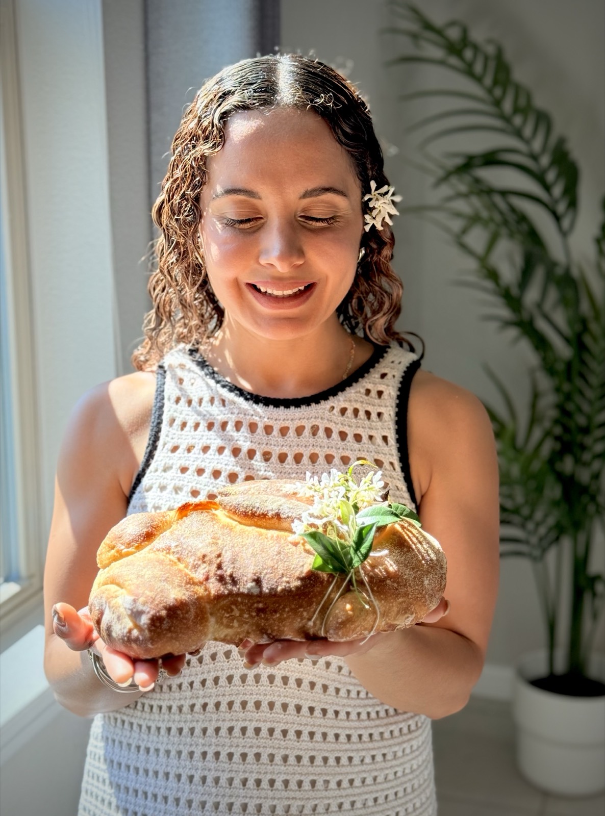Stephanie smiling down at a sandwich loaf in natural window light